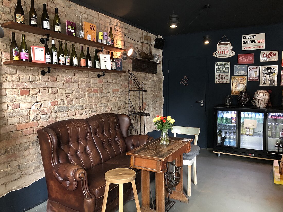 Zu sehen ist das Café Covent Garden von innen, mit einem Sitzplatz bestehend aus einer alten Ledercouch und einigen Bildern an der Wand. 
